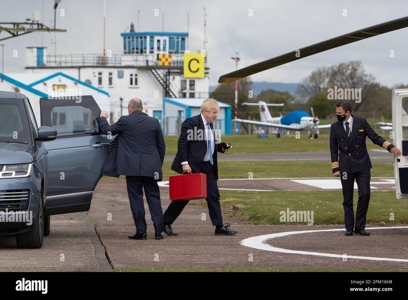 Aeropuerto verde de Wolverhampton Halfpenny, Reino Unido, 5th de mayo de 2021. El Primer Ministro Boris Johnson se encara en su helicóptero después de una visita aérea al País Negro el último día de campaña antes de las elecciones del Consejo Local de los jueves en Inglaterra. El Primer Ministro regresó de Stourbridge, donde se había unido anteriormente al alcalde de West Midlands Andy Street para dar un paseo en bicicleta junto al canal y ayudó a entregar folletos de campaña. Crédito: Paul Bunch / Alamy Live News. Foto de stock