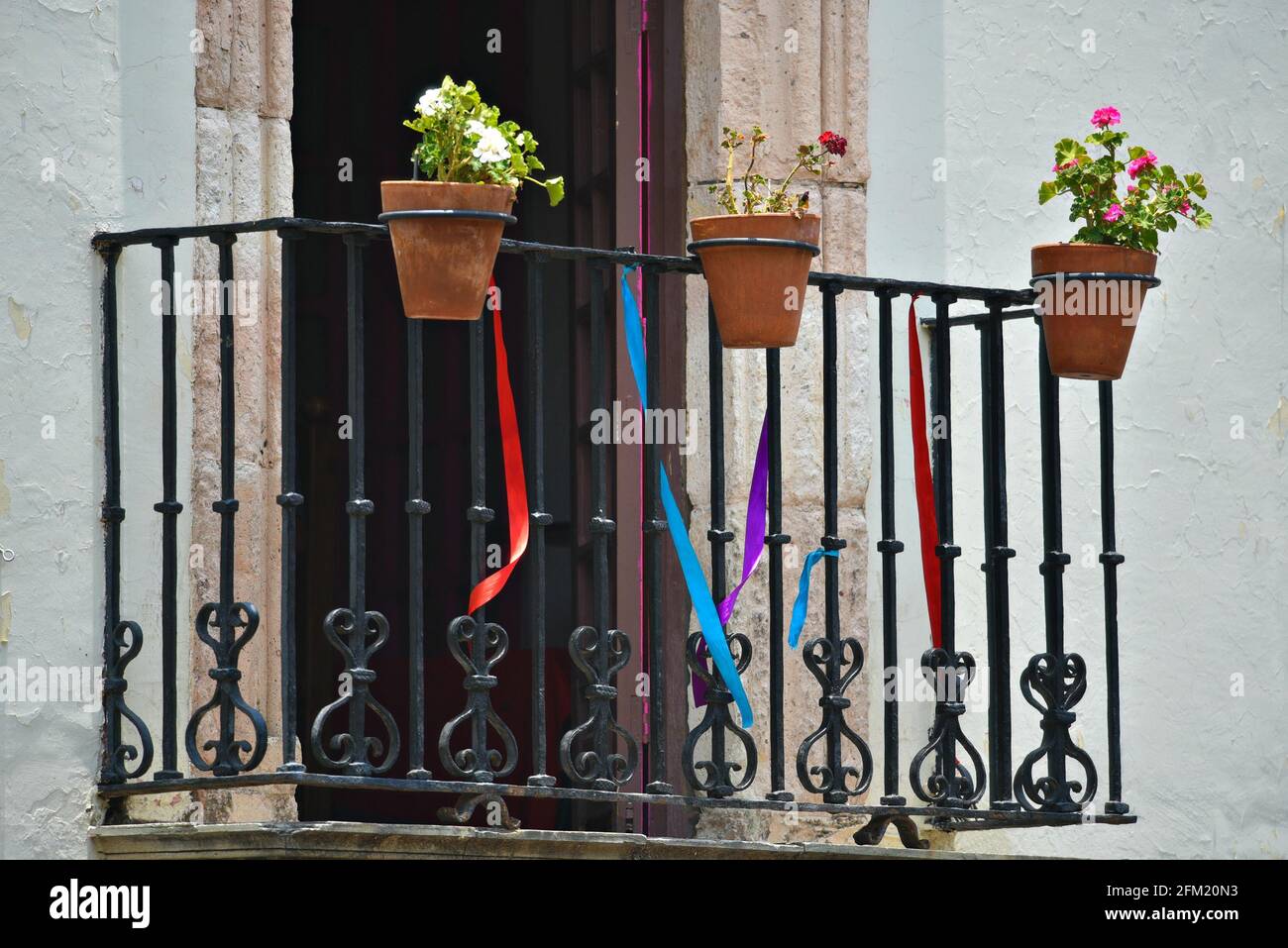 Balcón del edificio colonial español con barandilla de hierro forjado  artesanal y macetas de arcilla con flores en Guanajuato, México Fotografía  de stock - Alamy