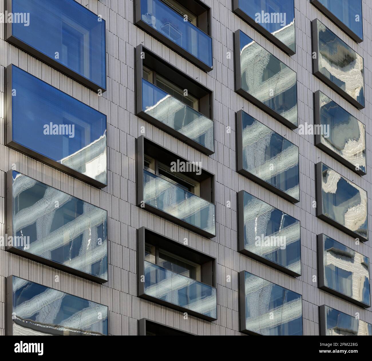 reflejos en las ventanas con espejos de un moderno edificio de gran altura Foto de stock
