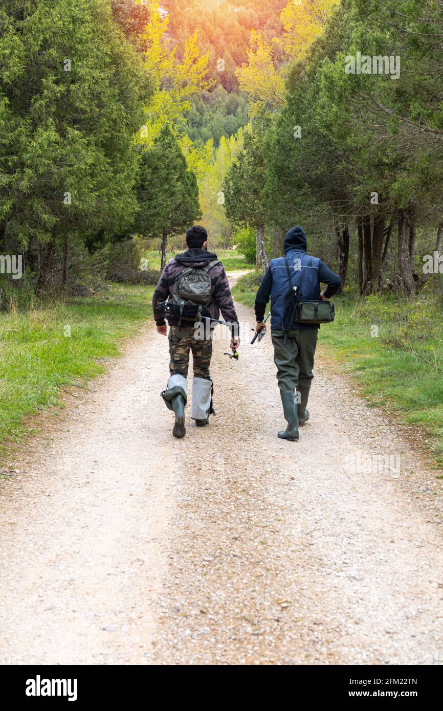 Dos j venes adolescentes con ropa de pesca botas de goma alta