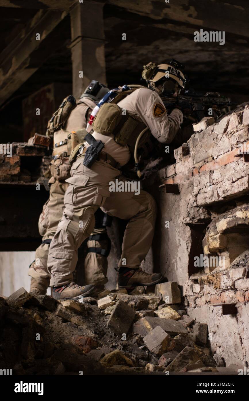 Dos tipos con uniformes militares estadounidenses se ponen de pie sobre  piedras en un edificio en ruinas, juego de deportes aerosuaves, simulación  de fuerzas militares Fotografía de stock - Alamy