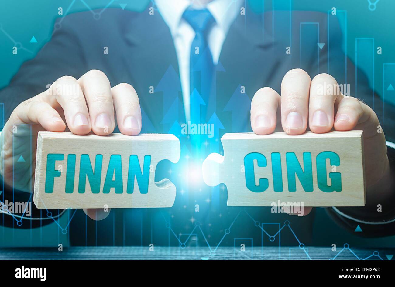 Businessman conecta rompecabezas con la palabra financiación. Invertir en un proyecto empresarial, recaudar fondos. Crédito, donaciones, impuestos, subvenciones de apoyo, ahorro Foto de stock