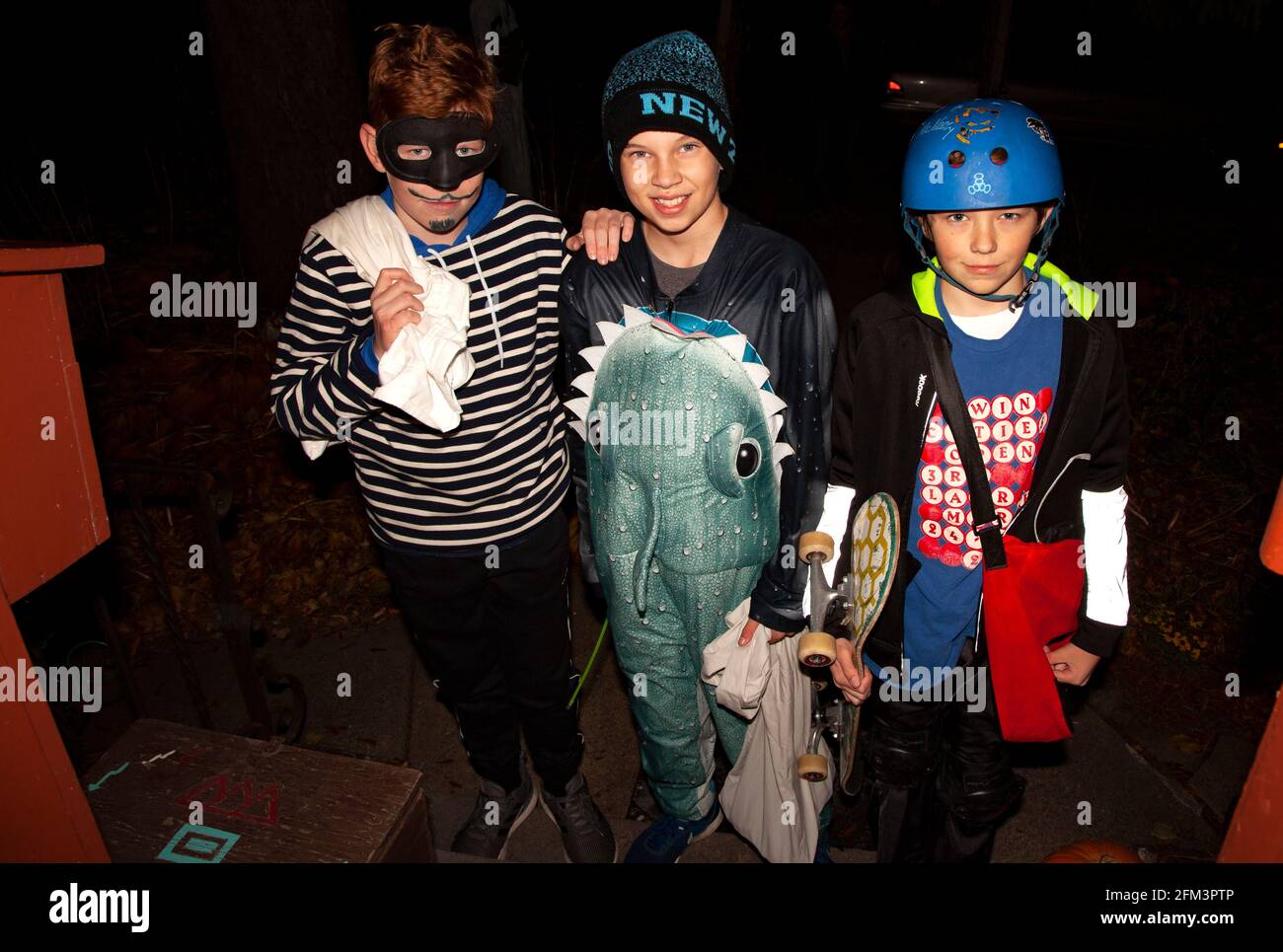 Truco de Halloween y tratadores disfrazados como un burglar de tiburón y skateboarder. St Paul Minnesota MN EE.UU Foto de stock