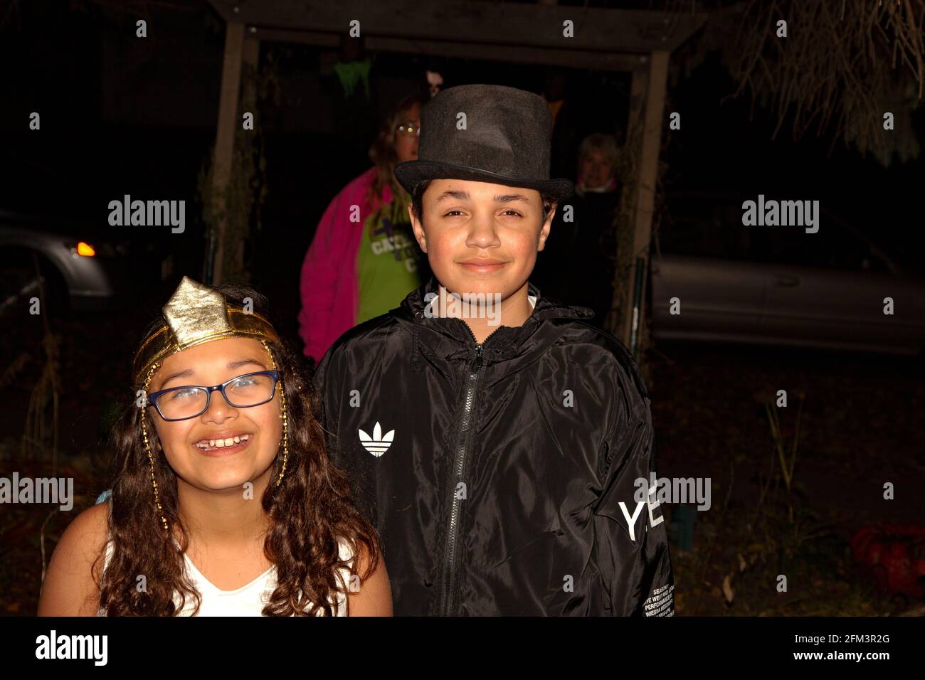 Sonriente truco de Halloween hispano o tratantes disfrazados princesa y escolta En negro St Paul Minnesota MN USA Foto de stock
