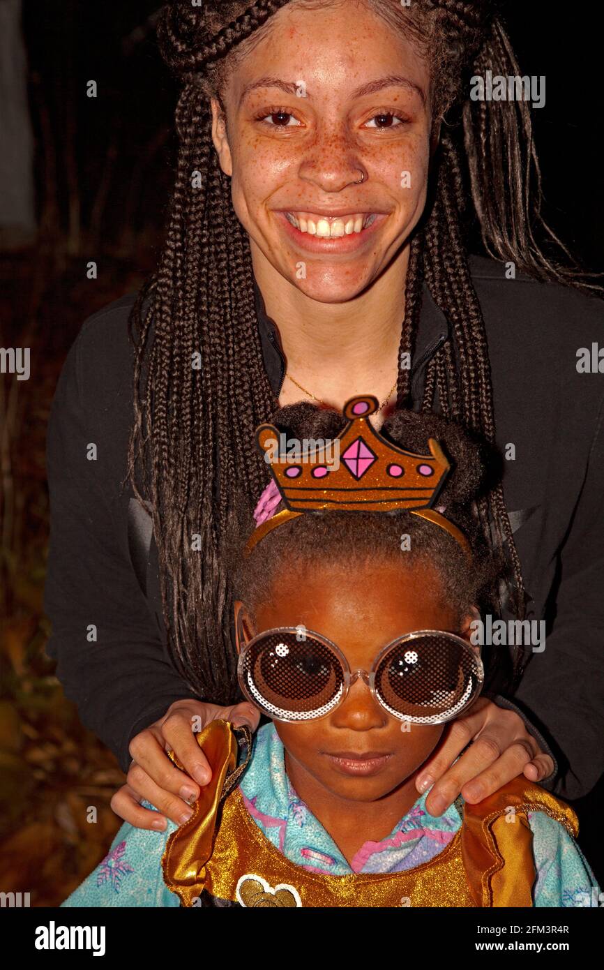 Truco de Halloween o el tratador disfrazados como una princesa usando grandes gafas de sol con mamá sonriendo detrás de ella. St Paul Minnesota MN EE.UU Foto de stock