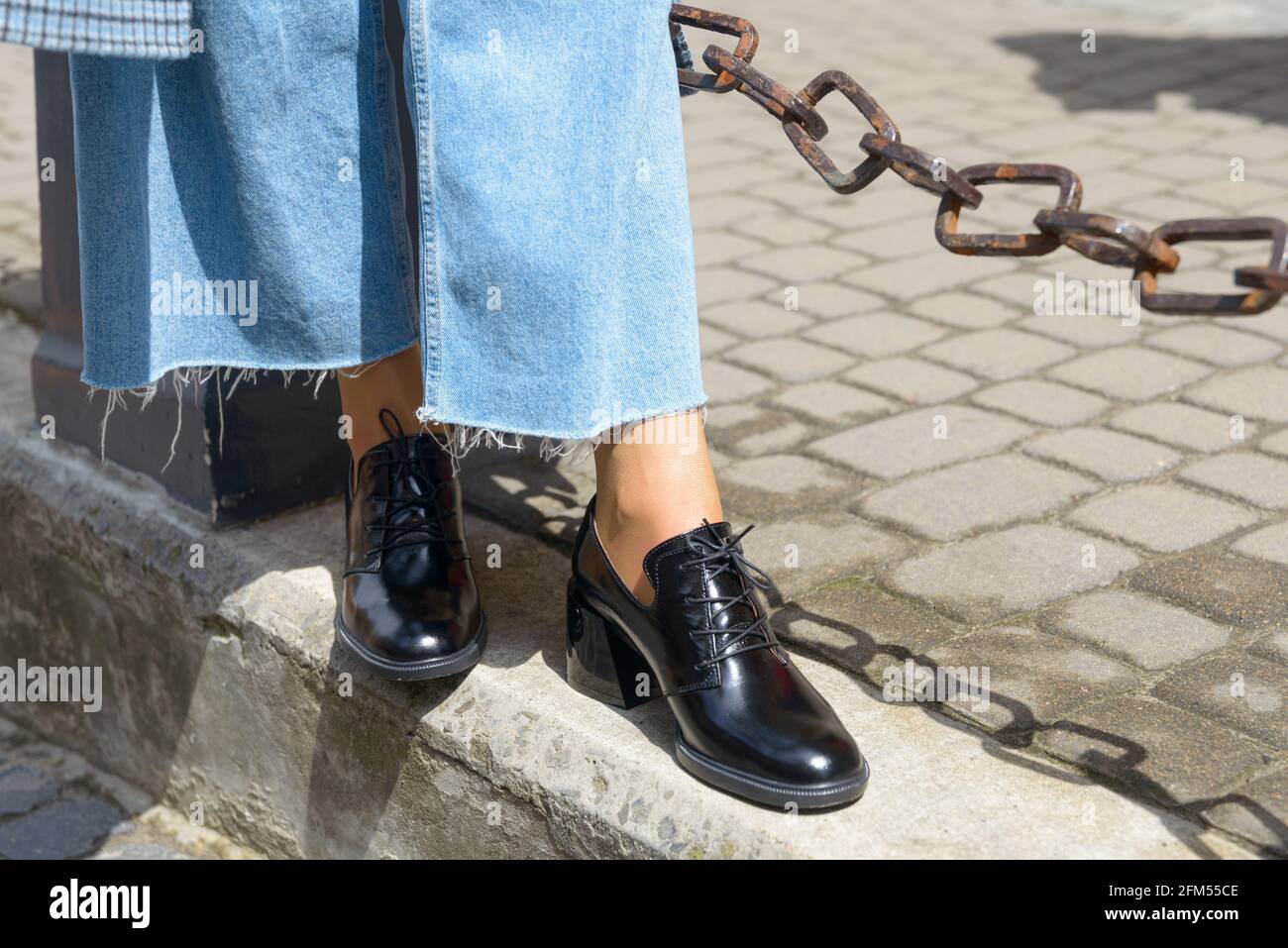 Botas de piel para mujer en primer plano. La chica camina con zapatos  negros brillantes estilo oxford Fotografía de stock - Alamy