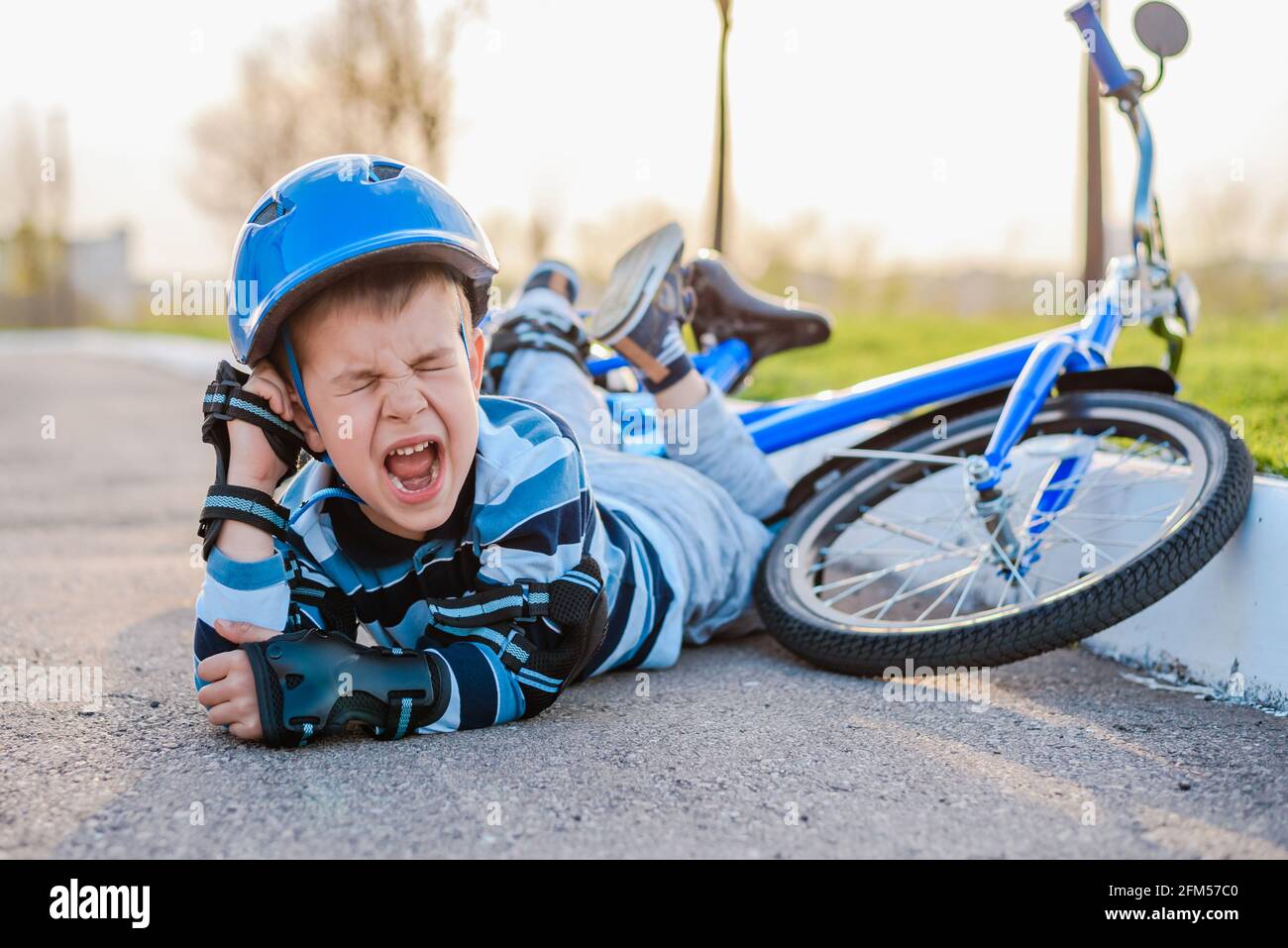 Un niño pequeño cayó de una bicicleta llorando y gritando con dolor