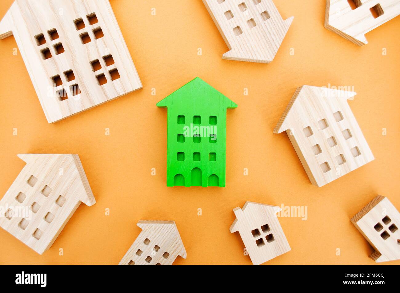 Muchas casas de madera en miniatura. Concepto de bienes raíces. Elija una vivienda asequible. Comprar y vender viviendas. Análisis de mercado. Demanda de vivienda. En aumento Foto de stock