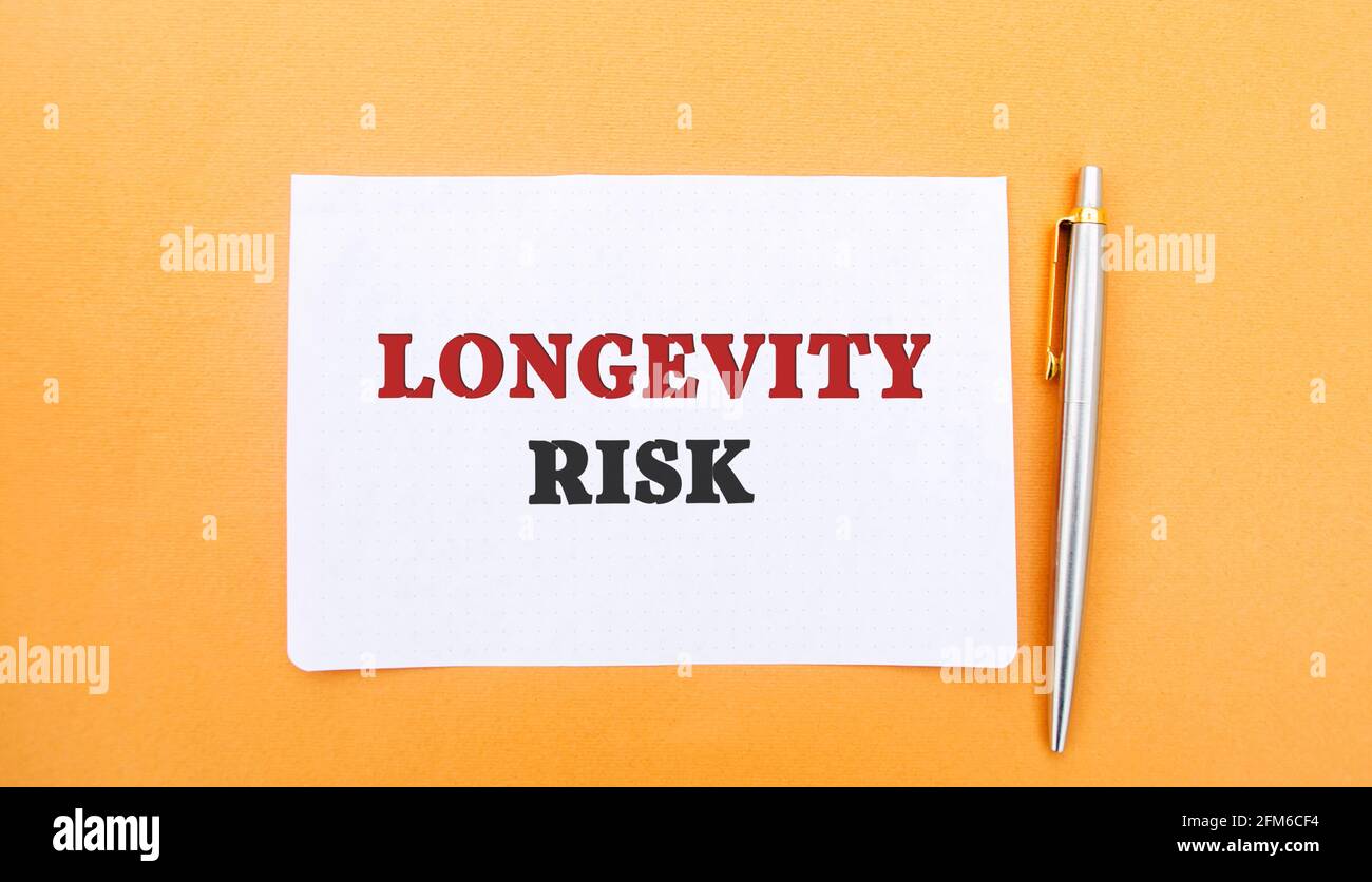 Una nota con la inscripción Longevity Risk y una pluma. Riesgo a largo plazo. Fondo de pensiones. Compañías de seguros. Riesgo de que las personas vivan más tiempo que curr Foto de stock