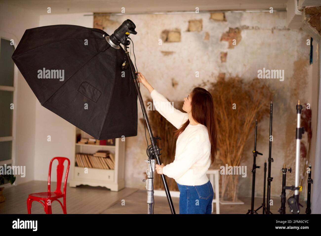 Concepto de trabajo creativo en el estudio fotográfico. Equipo de  fotografía de ajuste de la mujer preparándose para una fotografía  Fotografía de stock - Alamy
