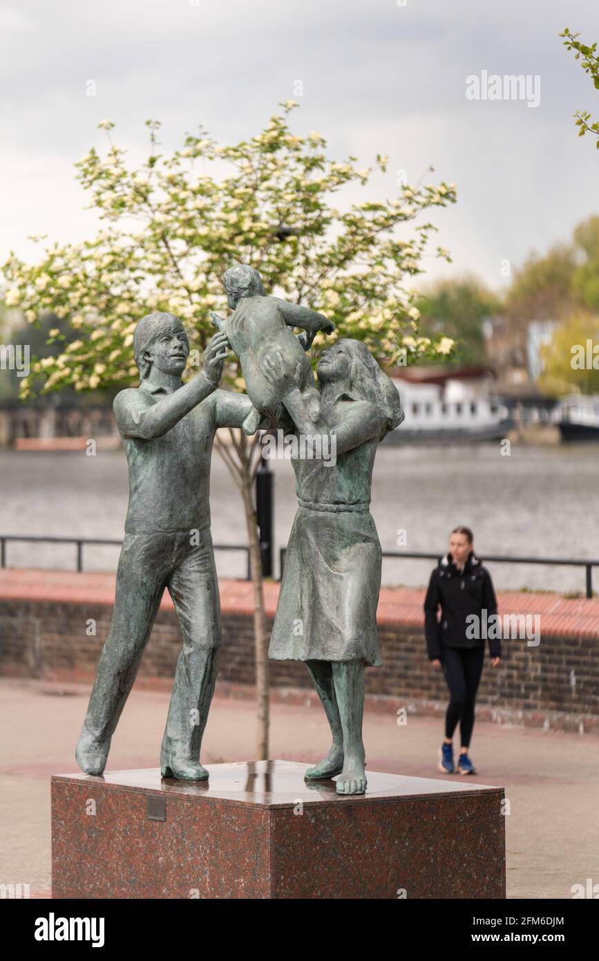 'In Town', una escultura que representa a dos padres que sostienen a su hijo pequeño en arboladura, Battersea, wandsworth, londres, inglaterra Foto de stock