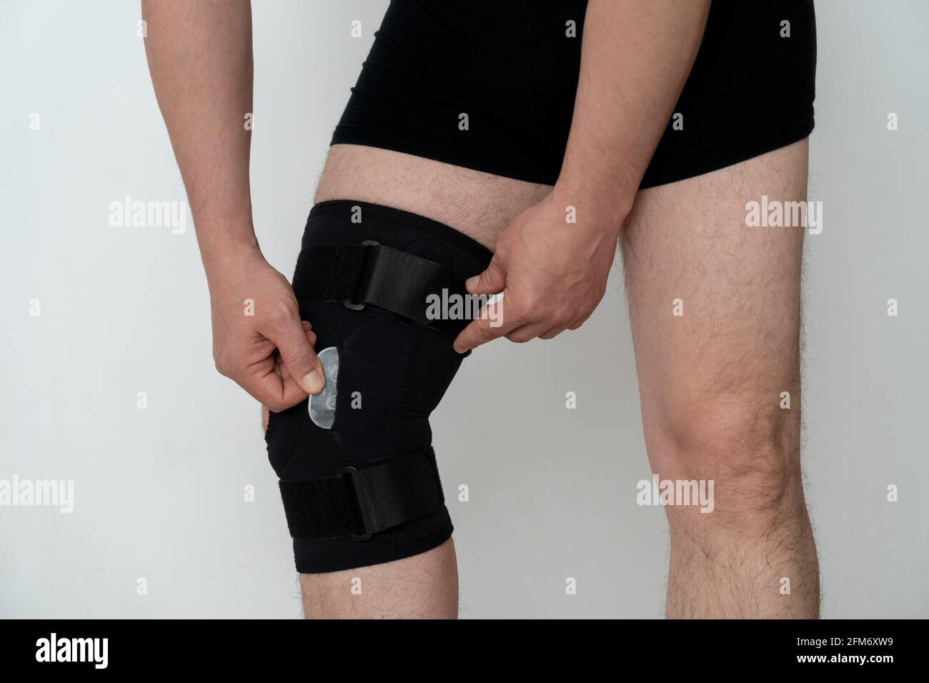 Soporte para piernas. Un hombre ajusta una ortosis negra en su pierna.  Copspace Fotografía de stock - Alamy
