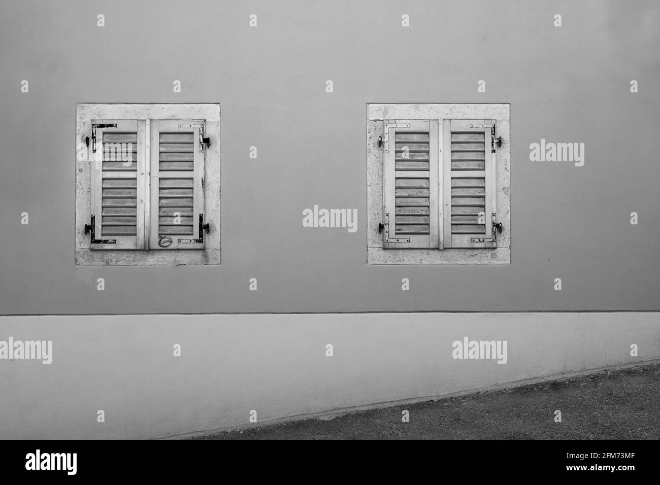 Trieste, Italia. 3 de mayo de 2021. Dos viejas ventanas de madera en una antigua casa rodaron de una calle cuesta arriba en el centro de la ciudad Foto de stock
