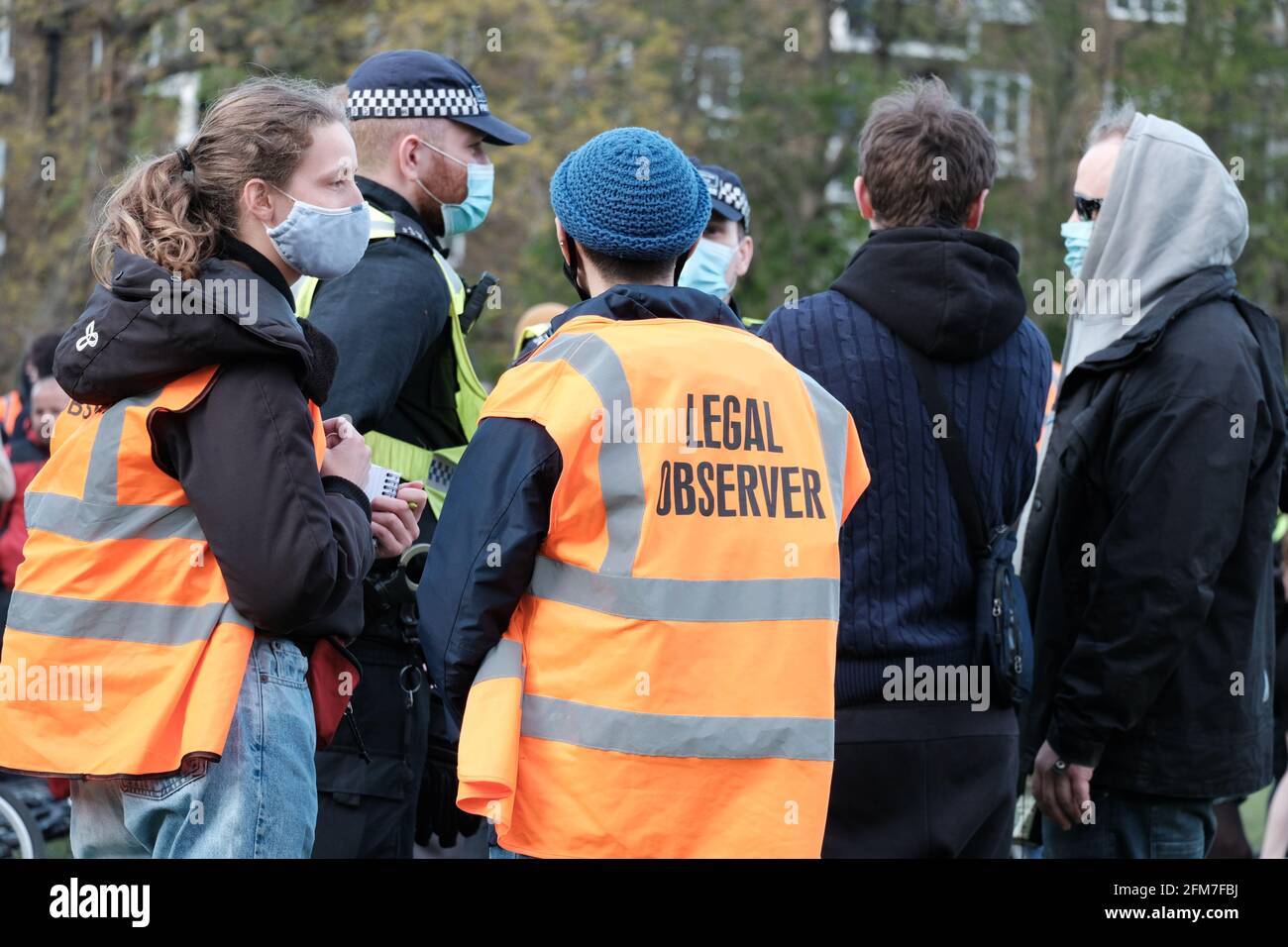 Observadores legales, voluntarios entrenados e identificados por sus chalecos de alta visibilidad monitorean las interacciones policiales en una protesta Kill the Bill en Vauxhall, Londres Foto de stock