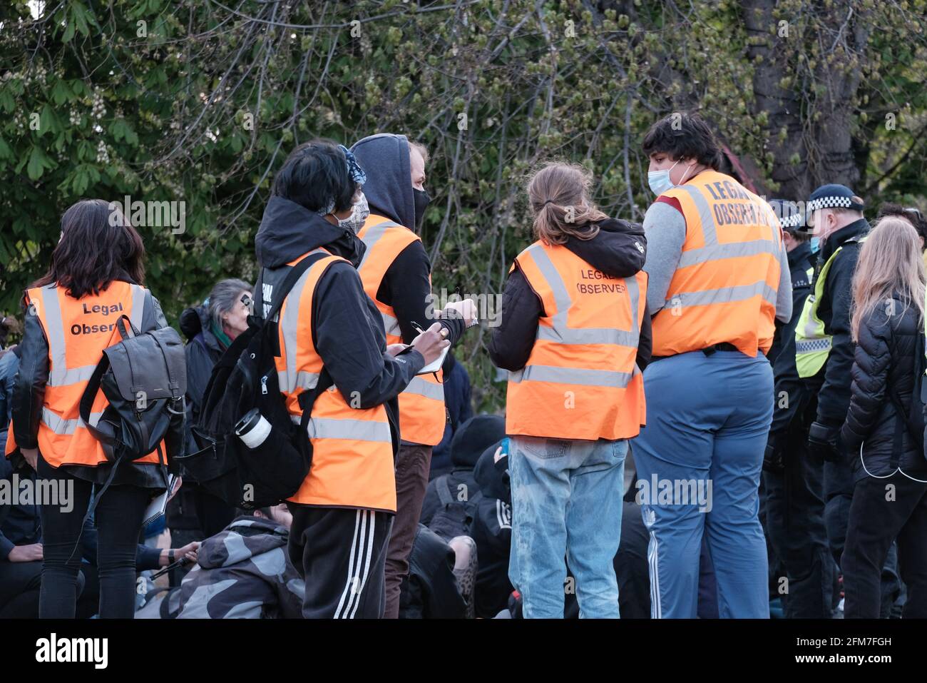 Observadores legales, voluntarios entrenados e identificados por sus chalecos de alta visibilidad monitorean las interacciones policiales en una protesta Kill the Bill en Vauxhall, Londres Foto de stock
