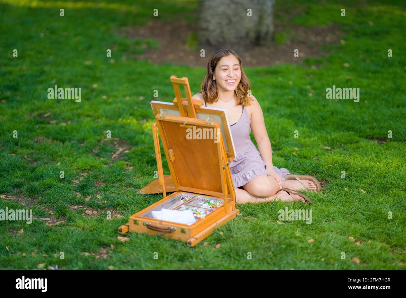 Petite joven mujer asiática de la pintura del estudiante en el parque usando Un gabinete Easel Foto de stock