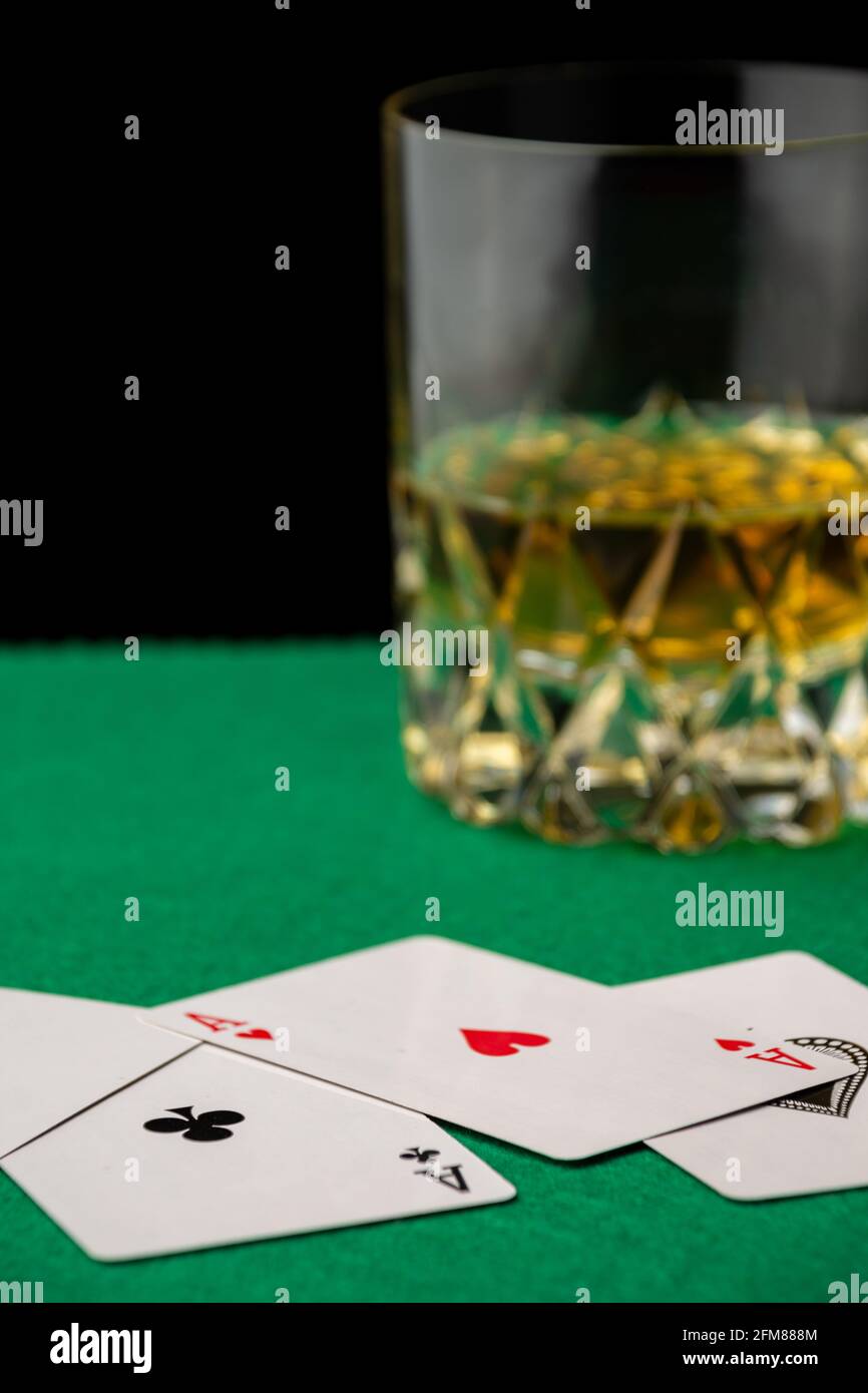 Primer plano de las cartas de póquer en mantel verde con cristal de whisky,  desenfocado, fondo negro, vertical, con espacio de copia Fotografía de  stock - Alamy