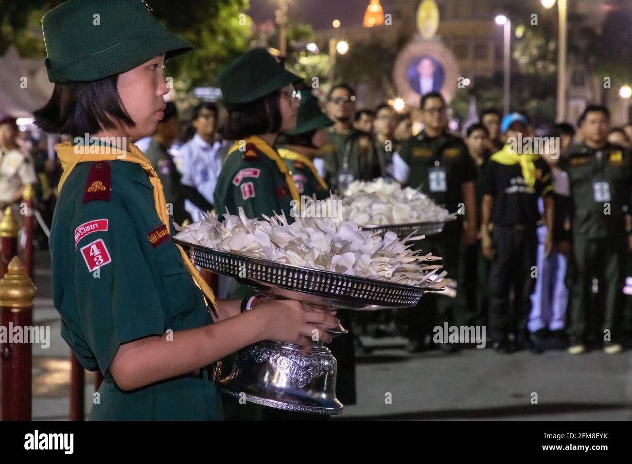Niña con uniforme con flores en el funeral del Rey Rama IX, Bangkok, Tailandia Foto de stock