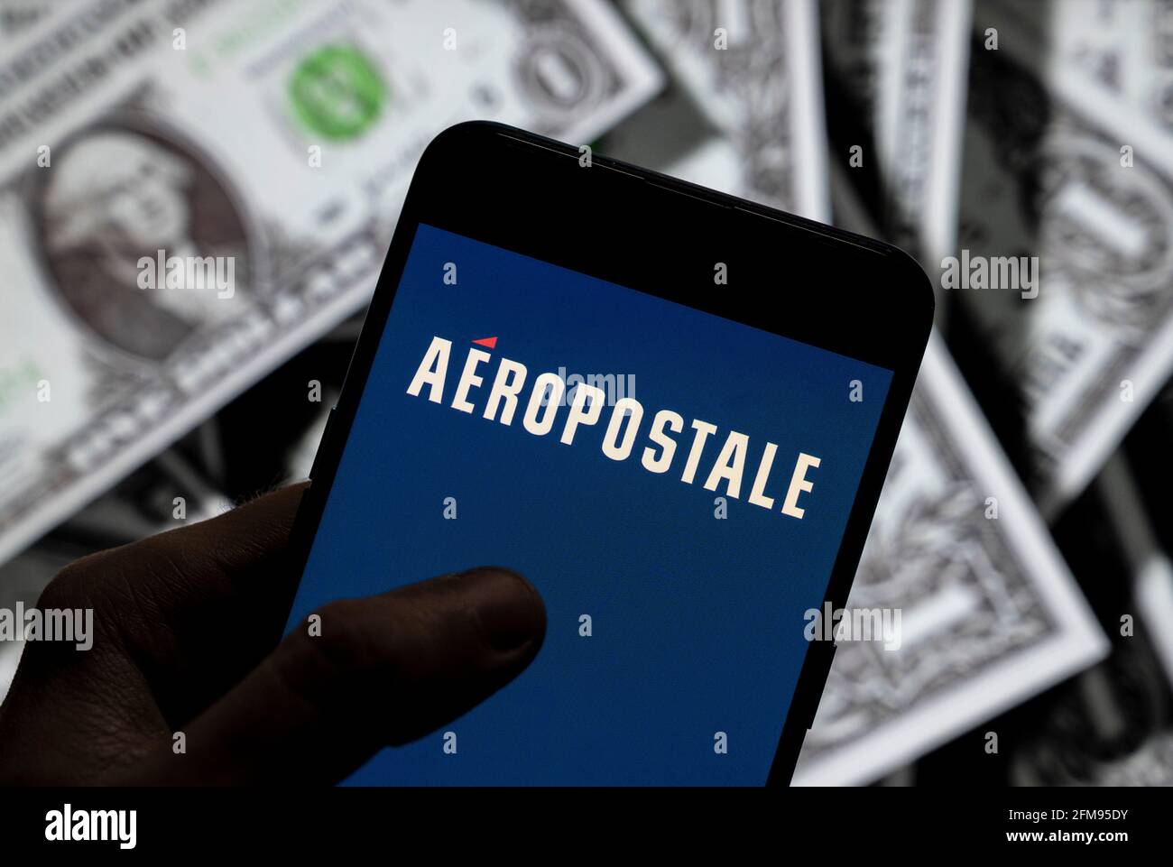 China. 21st de Abr de 2021. En esta ilustración de la foto se muestra el logotipo  Aeropostale del minorista de ropa estadounidense ubicado en un smartphone  con divisa USD (dólar de los