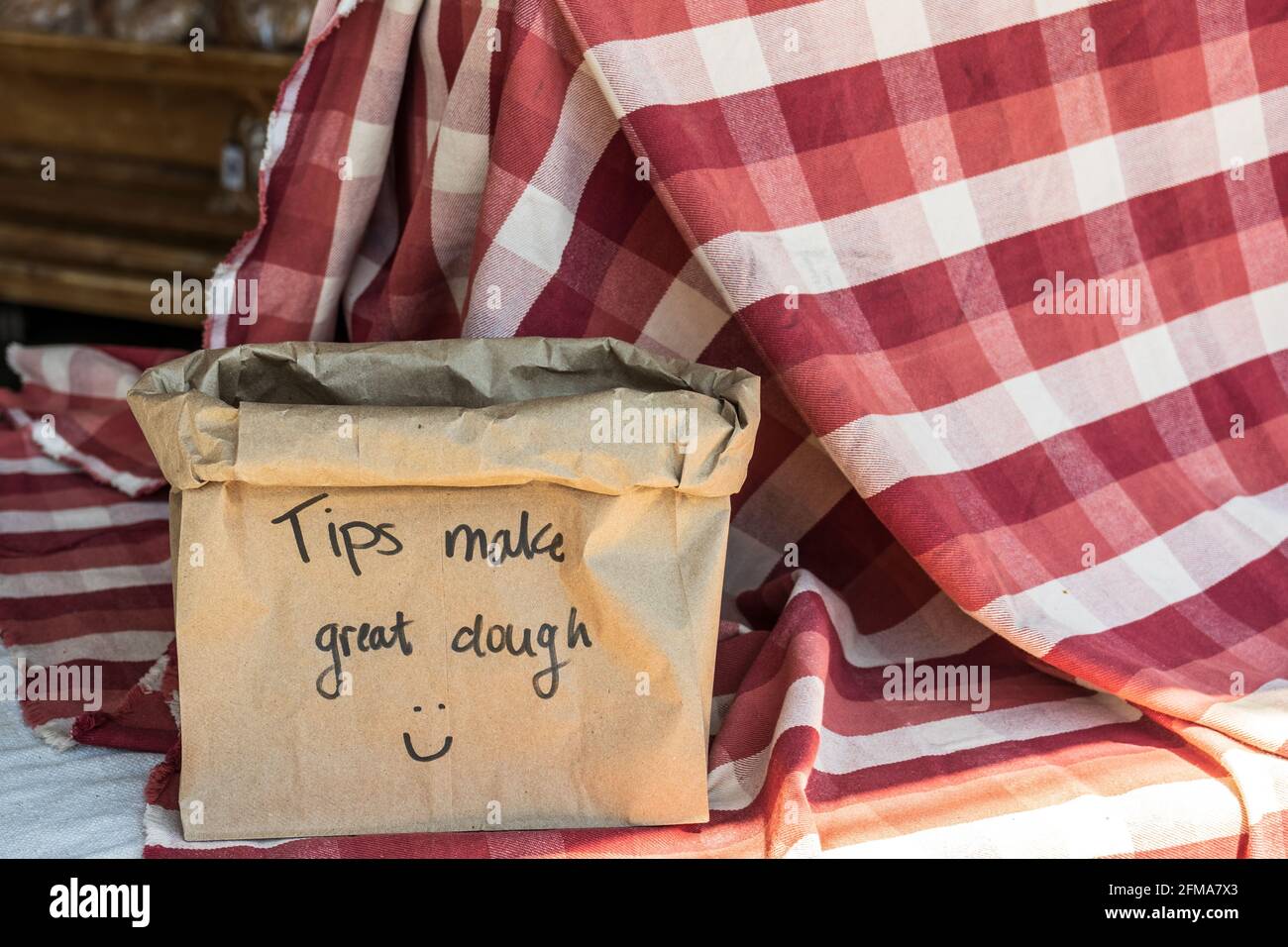 Consejos Haga una masa estupenda en una bolsa de papel marrón una mesa cubierta con manteles de cuadros rojos y blancos Foto de stock