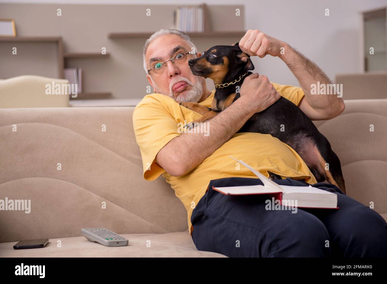 Anciano con perro en casa Fotografía de stock - Alamy