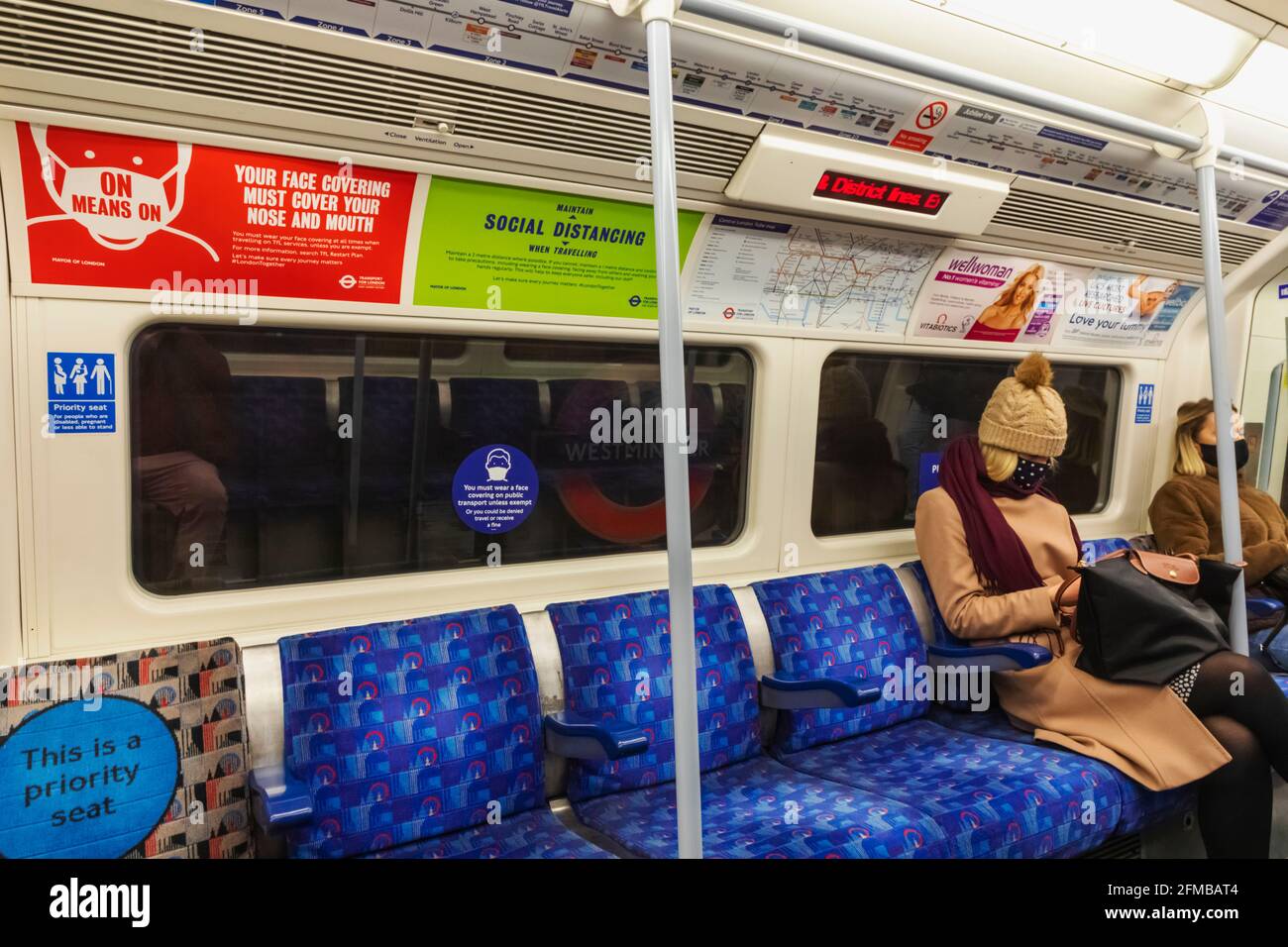 Inglaterra, Londres, mujeres pasajeros en el metro usando máscaras de cara durante la pandemia de COVID Foto de stock