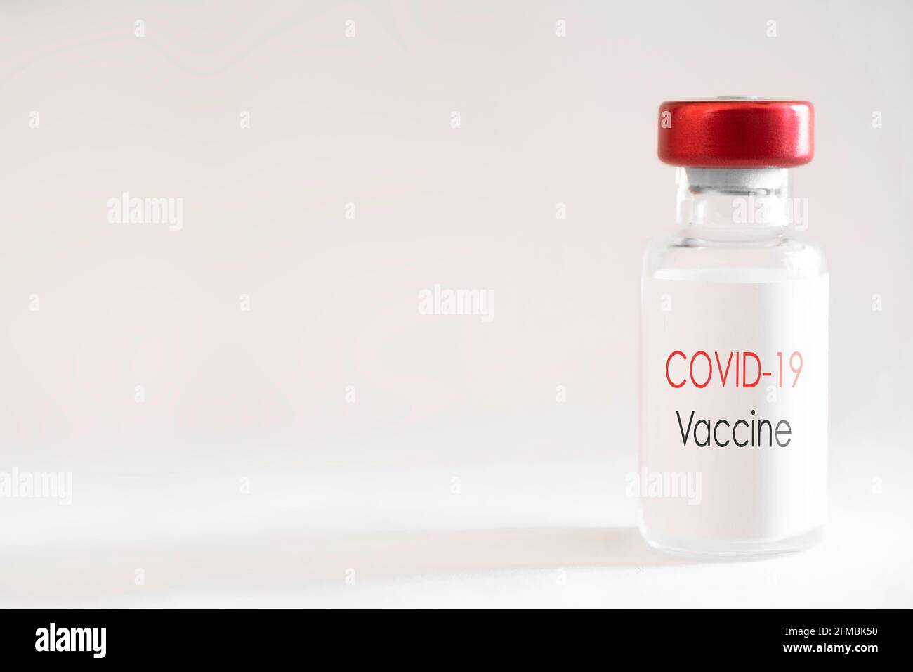 Botella de vacuna con tapón rojo y el texto en inglés 'Covid19 vaccine' sobre un fondo blanco