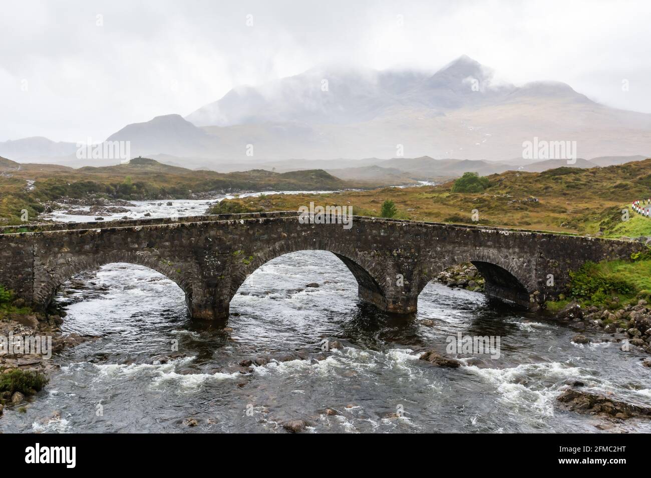 Antiguo puente de piedra de tres arcos sobre el río Sligachan en la isla de Skye en Escocia. Vista en un día foggy Foto de stock