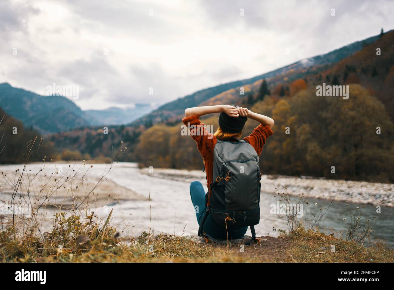 mujer viajera con una mochila en su espalda gestos con sus manos y mira las  montañas en la distancia Fotografía de stock - Alamy