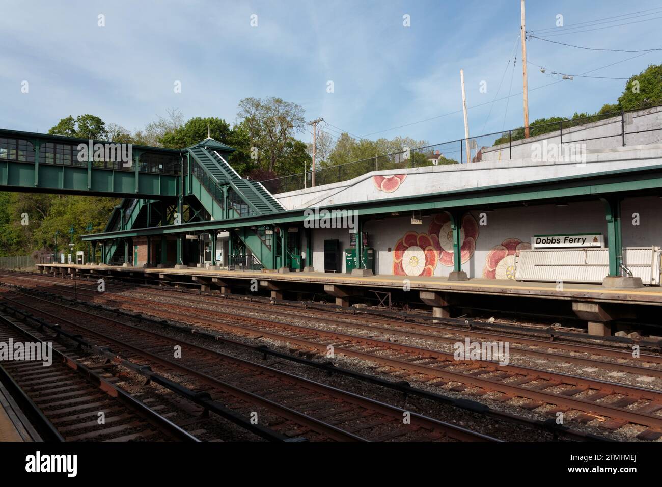 Estación de tren Dobbs Ferry Metro North, pequeña ciudad de transporte en el interior del estado de Nueva York, vista a través de las vías del tren con paso elevado peatonal en el fondo Foto de stock
