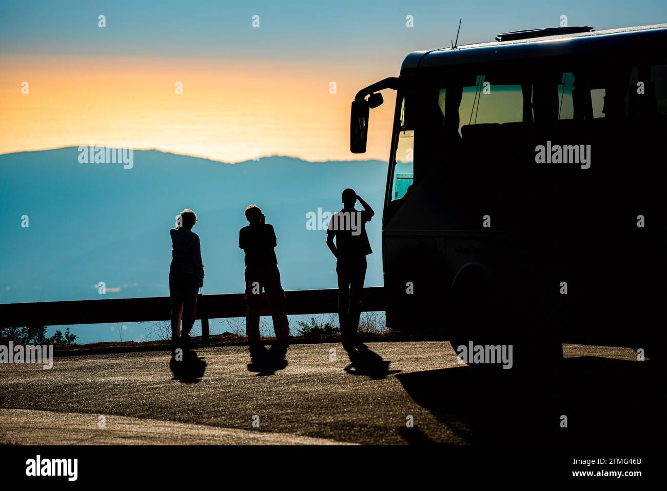 Turistas y autobús en carretera en las montañas de la bahía de Kotor, Montenegro. Paisaje de puesta de sol. Viajes a Europa. Foto de stock