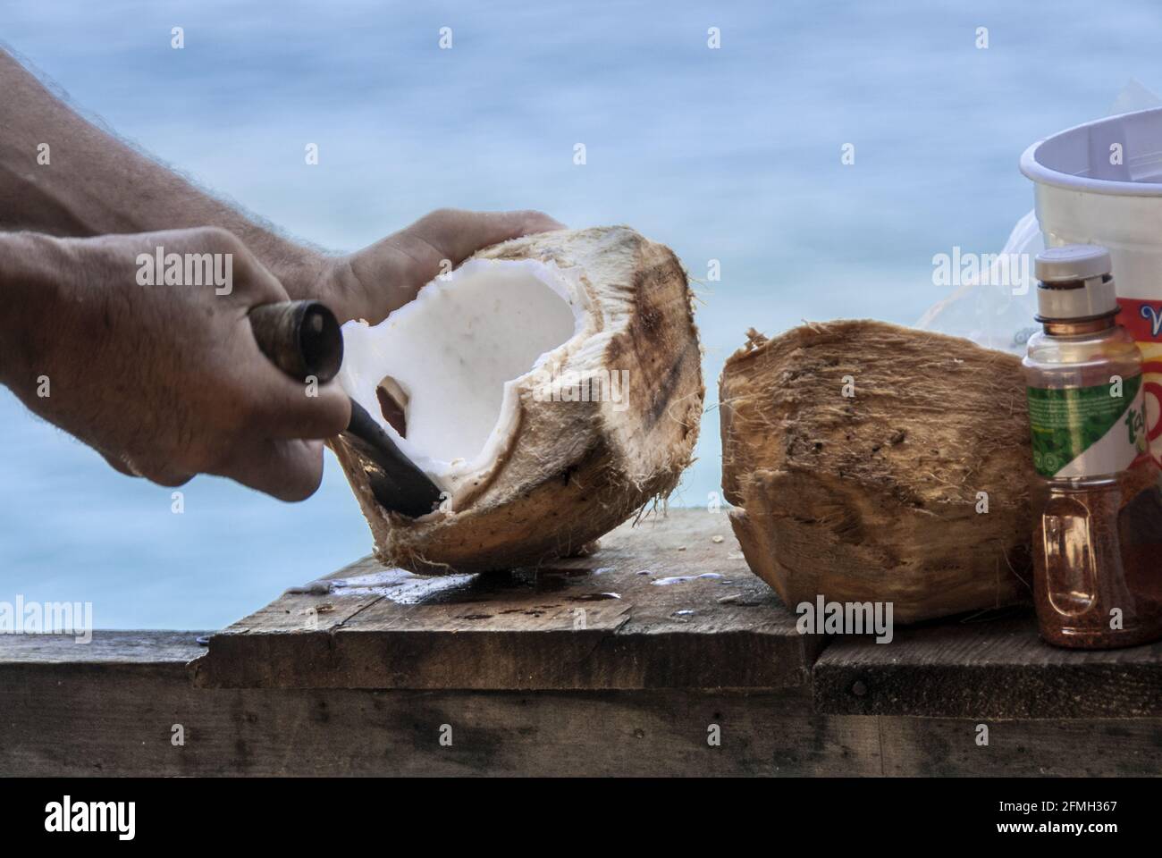 Primer plano del hombre cortando coco fresco en el kiosco de la carretera en la Bahía de Banderas, Puerto Vallarta en la costa del Pacífico de México. #613PV Foto de stock