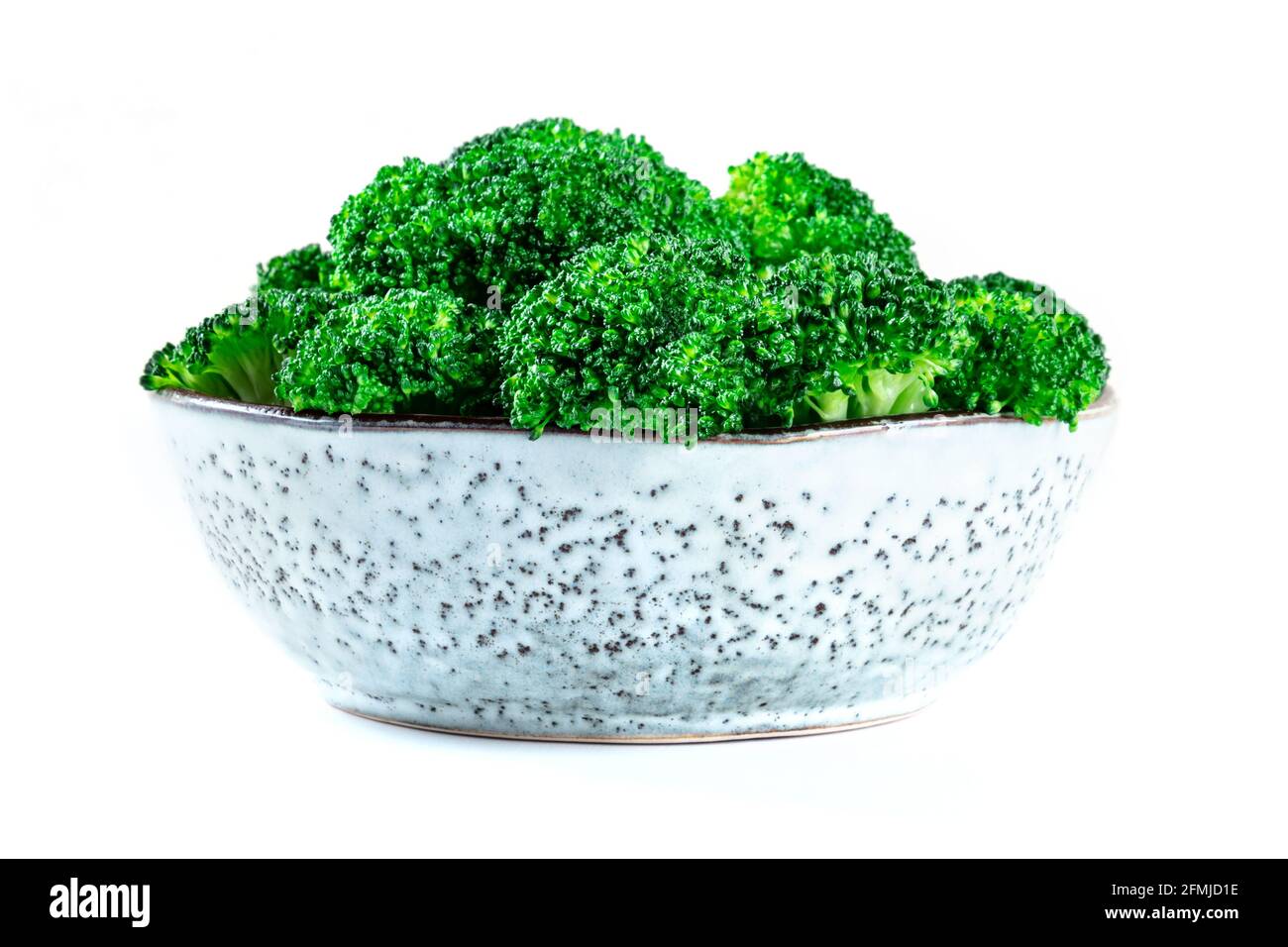 Brócoli en un tazón, vista lateral, aislado sobre un fondo blanco. Floretes de brócoli hervidos, una comida vegana detox saludable Foto de stock
