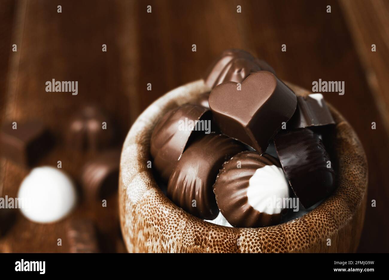 Detalle de dos chocolates en forma de corazón en su caja dorada. Día Internacional del Chocolate. Espacio de copia Foto de stock