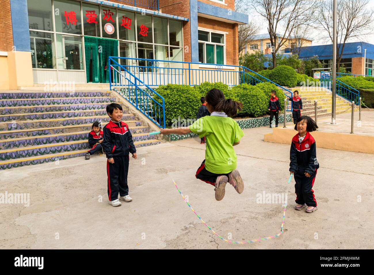 Los estudiantes saltan soga durante su tiempo de recreo en la escuela BOAI en Shanxi, China Foto de stock