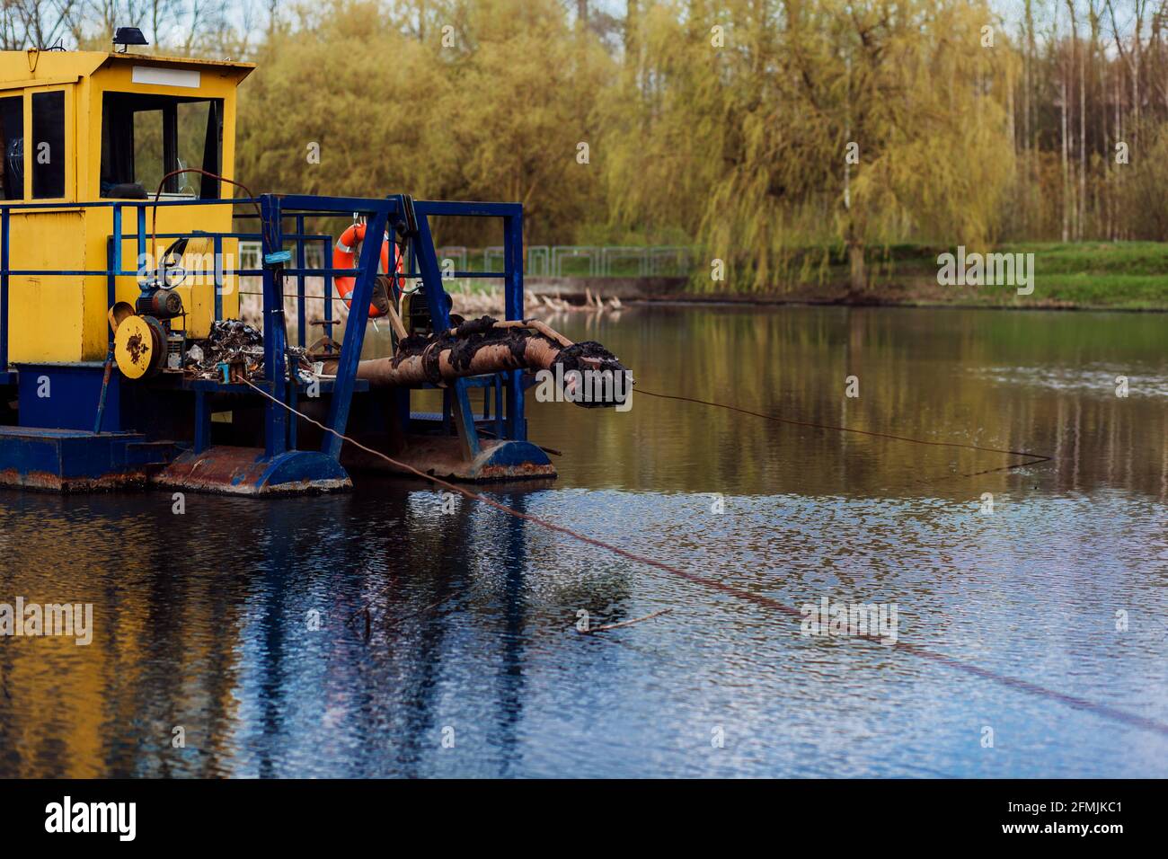 el barco industrial limpia un río o un lago. ecología Foto de stock