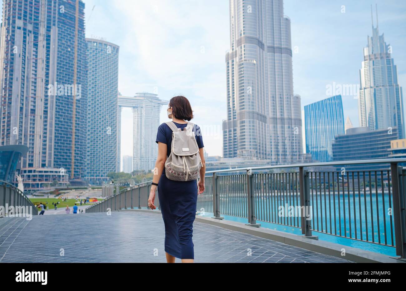 Joven hermosa mujer disfrutando de la vista del centro de Dubai. Disfrute de viajar por los Emiratos Árabes Unidos. Vista desde la parte trasera o trasera, la dama camina Foto de stock