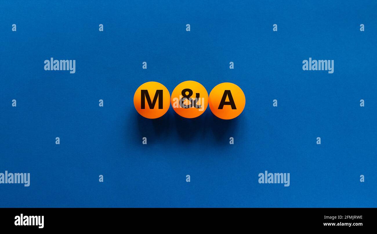 Símbolo de fusiones y adquisiciones. Concepto de palabra 'M y A, fusiones y adquisiciones' sobre bolas de tenis de mesa naranja sobre un hermoso fondo azul. Negocios Foto de stock