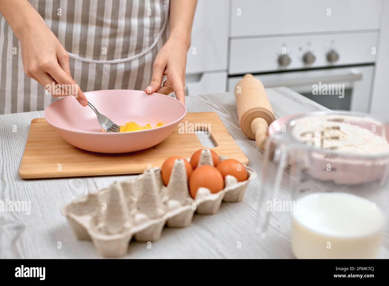 La mujer bate los huevos en un tazón. Ama de casa cocinando en la cocina  Fotografía de stock - Alamy