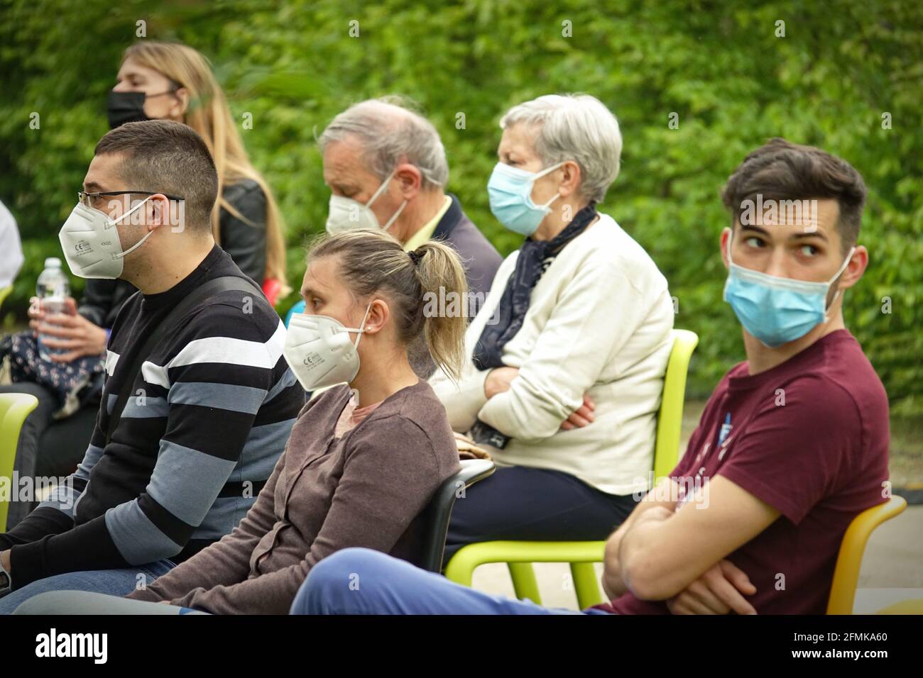 El público que llevaba máscaras de covid al principio juega en un parque al aire libre para la reapertura post-pandémica. Milán, Italia - Mayo 2021 Foto de stock