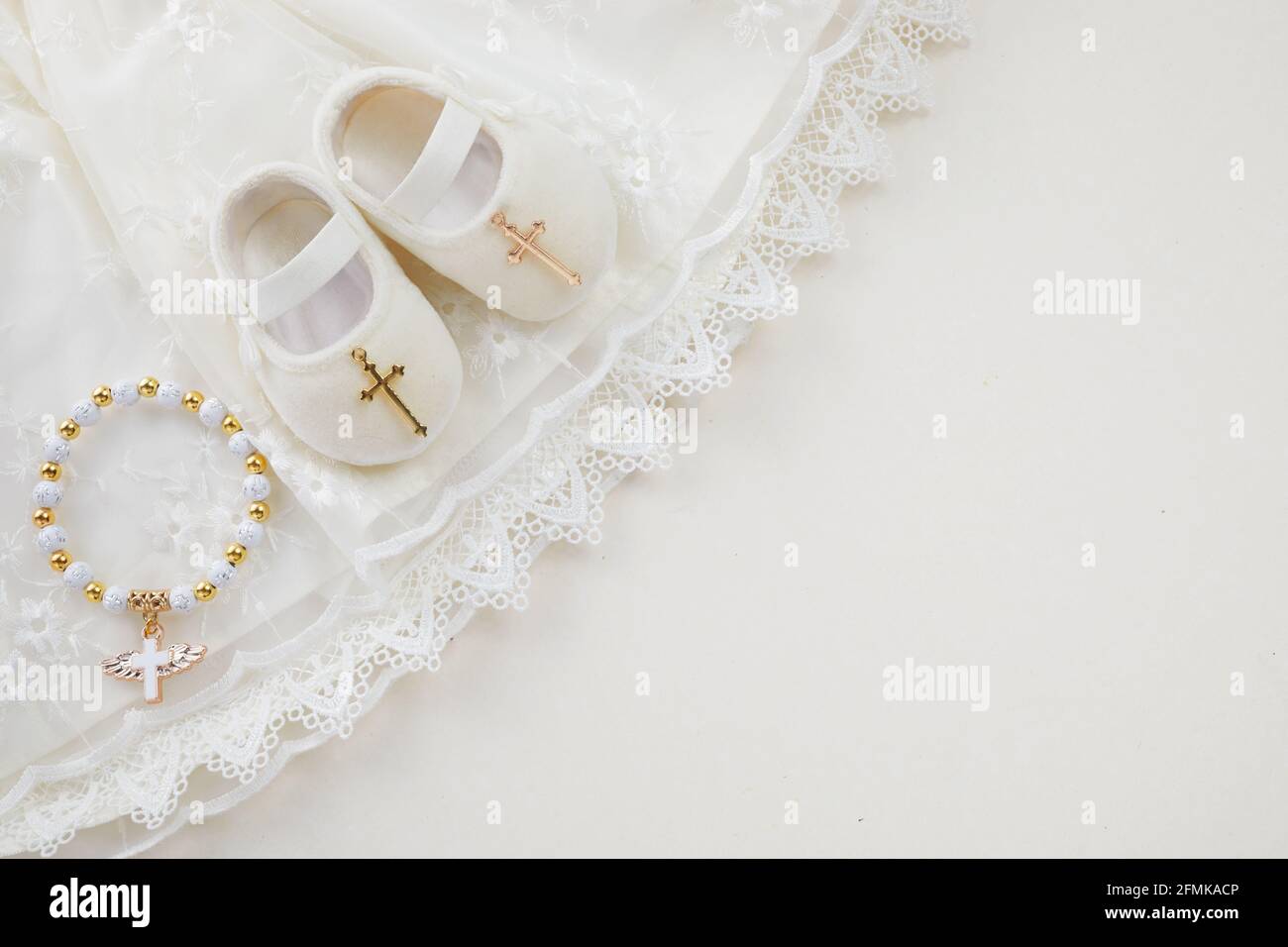 Bautizo de fondo con el bautismo de ropa de bebé, zapatos, y cruz sobre fondo pastel Foto de stock