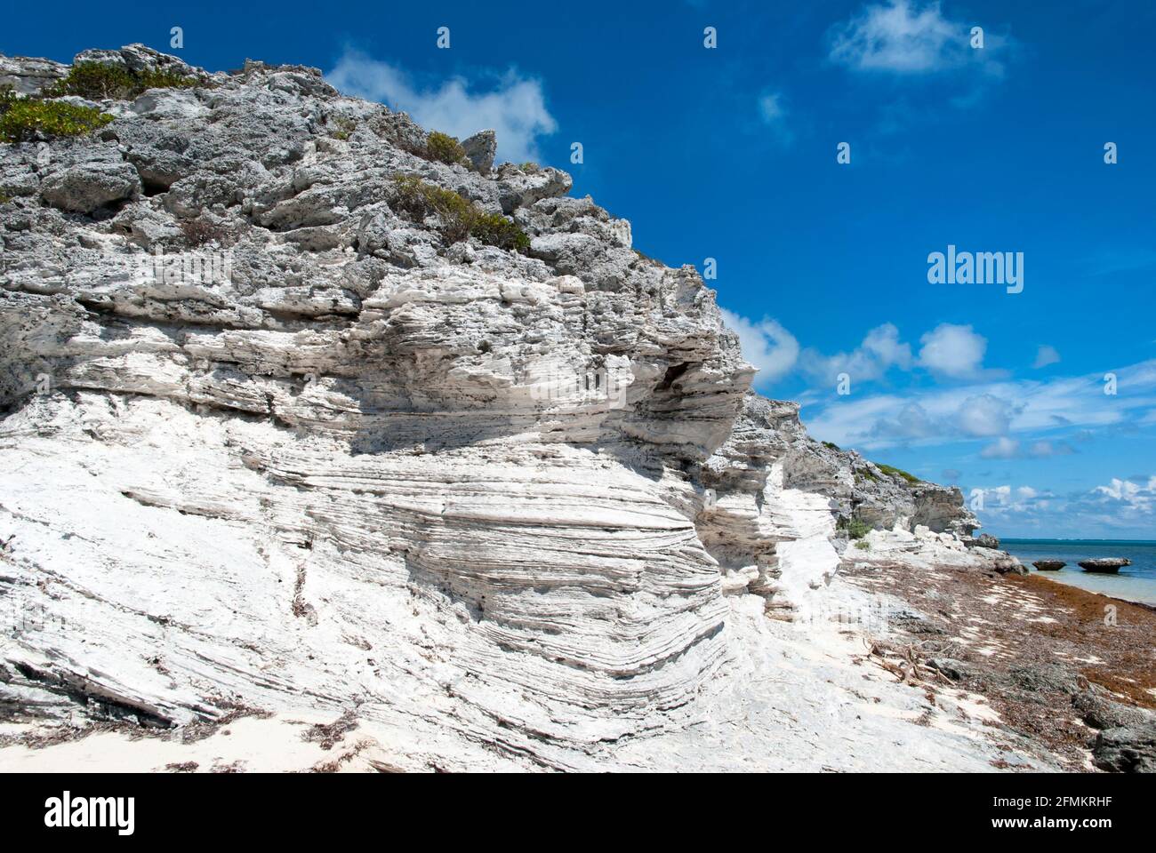 El color blanco escarpado erosionó las rocas en la playa de la isla de Grand Turk (Islas Turcas y Caicos). Foto de stock