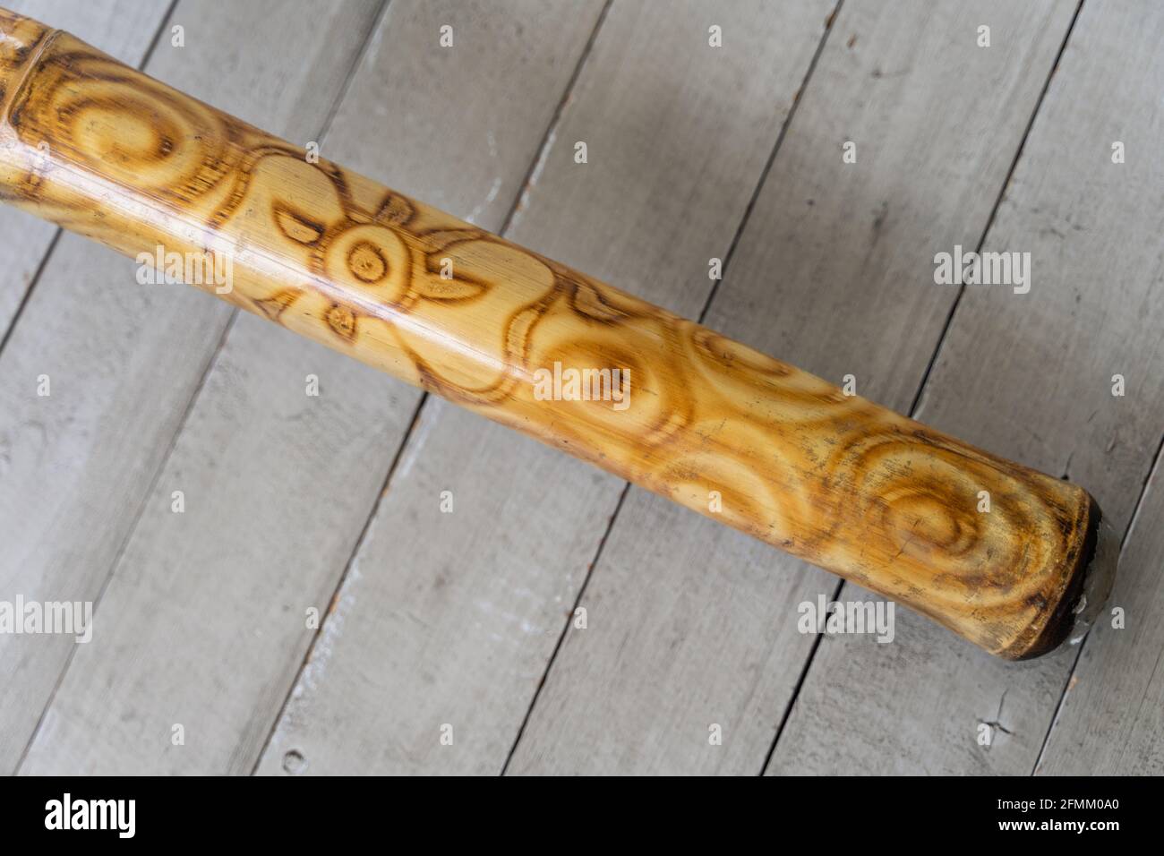 Didgeridoo instrumento de música de primer plano sobre fondo de pizarras  grises. Trompeta australiana tradicional de madera y decorada con un diseño  abstracto Fotografía de stock - Alamy