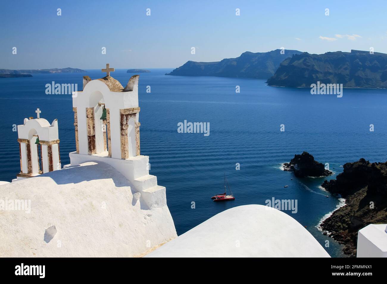 Campanarios de la iglesia griega tradicional contra el mar azul y el cielo, Oia, Santorini, Grecia Foto de stock