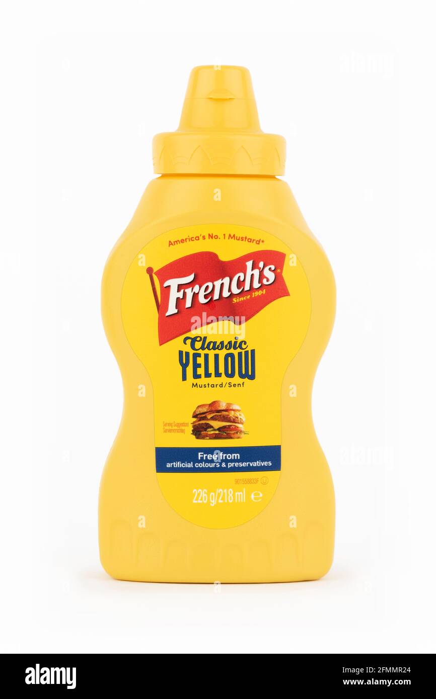 Una botella de mostaza amarilla de clase francesa disparó sobre un fondo blanco. Foto de stock