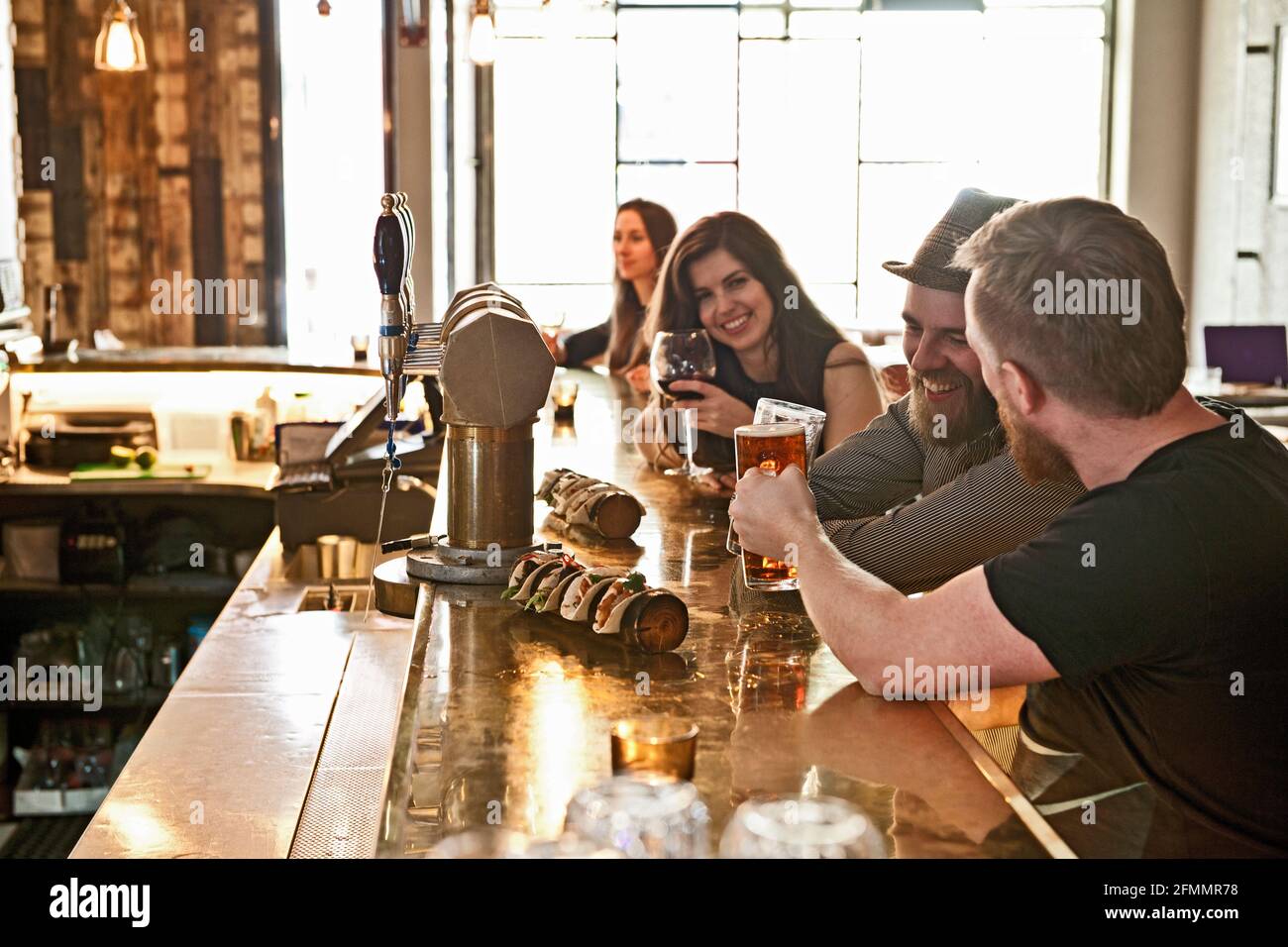 Amigos que lo pasaban bien en el bar hipster en Reykjavik Foto de stock