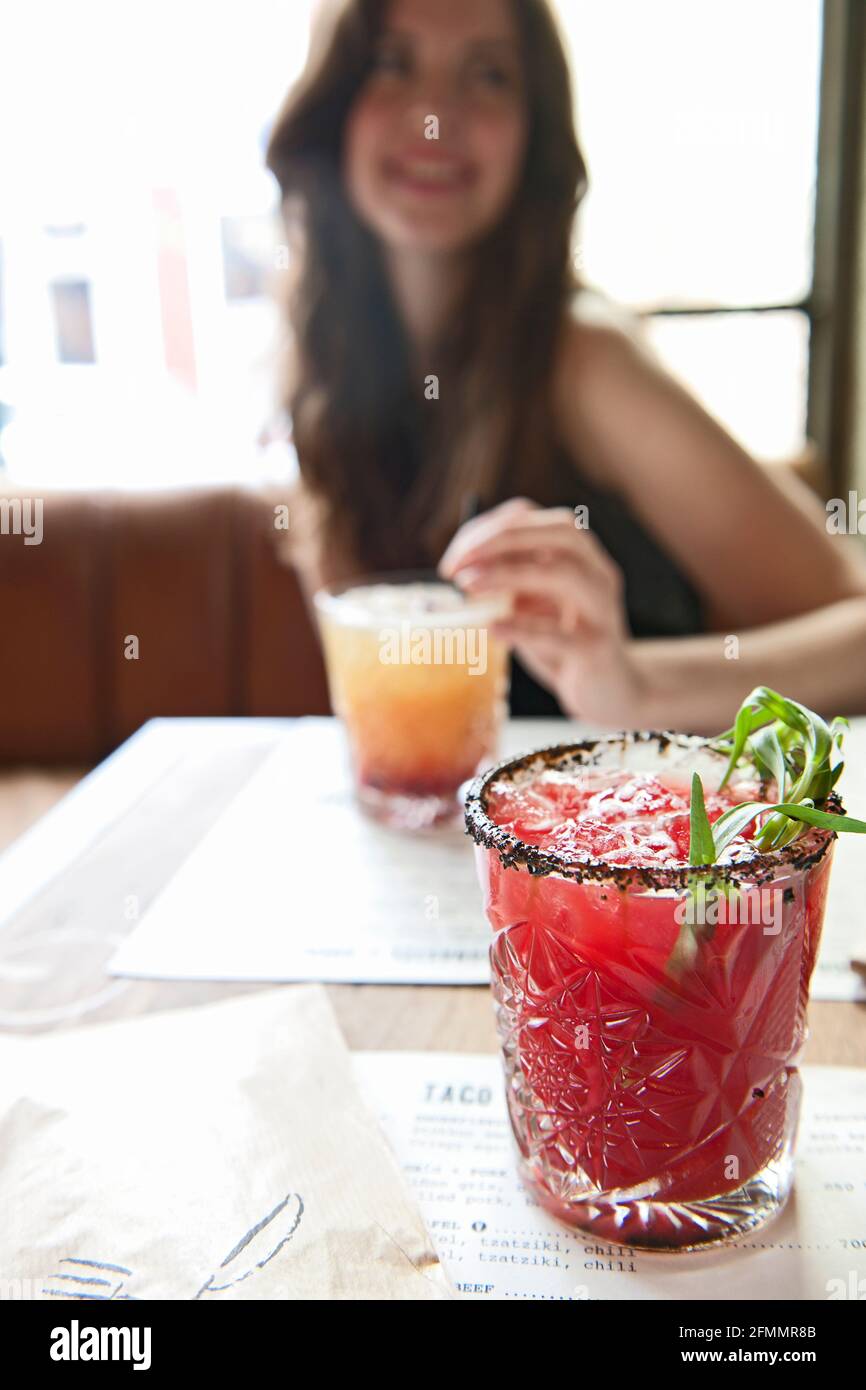 Una mujer joven bebiendo un cóctel en el bar hipster de Reykjavik Foto de stock