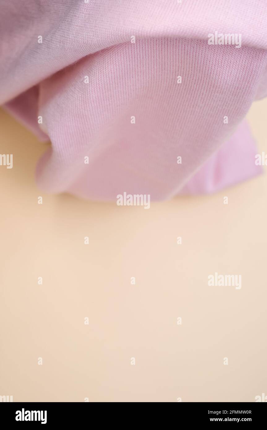 Foto vertical de tejido rosa con fondo borroso de pastel naranja con espacio de copia Foto de stock