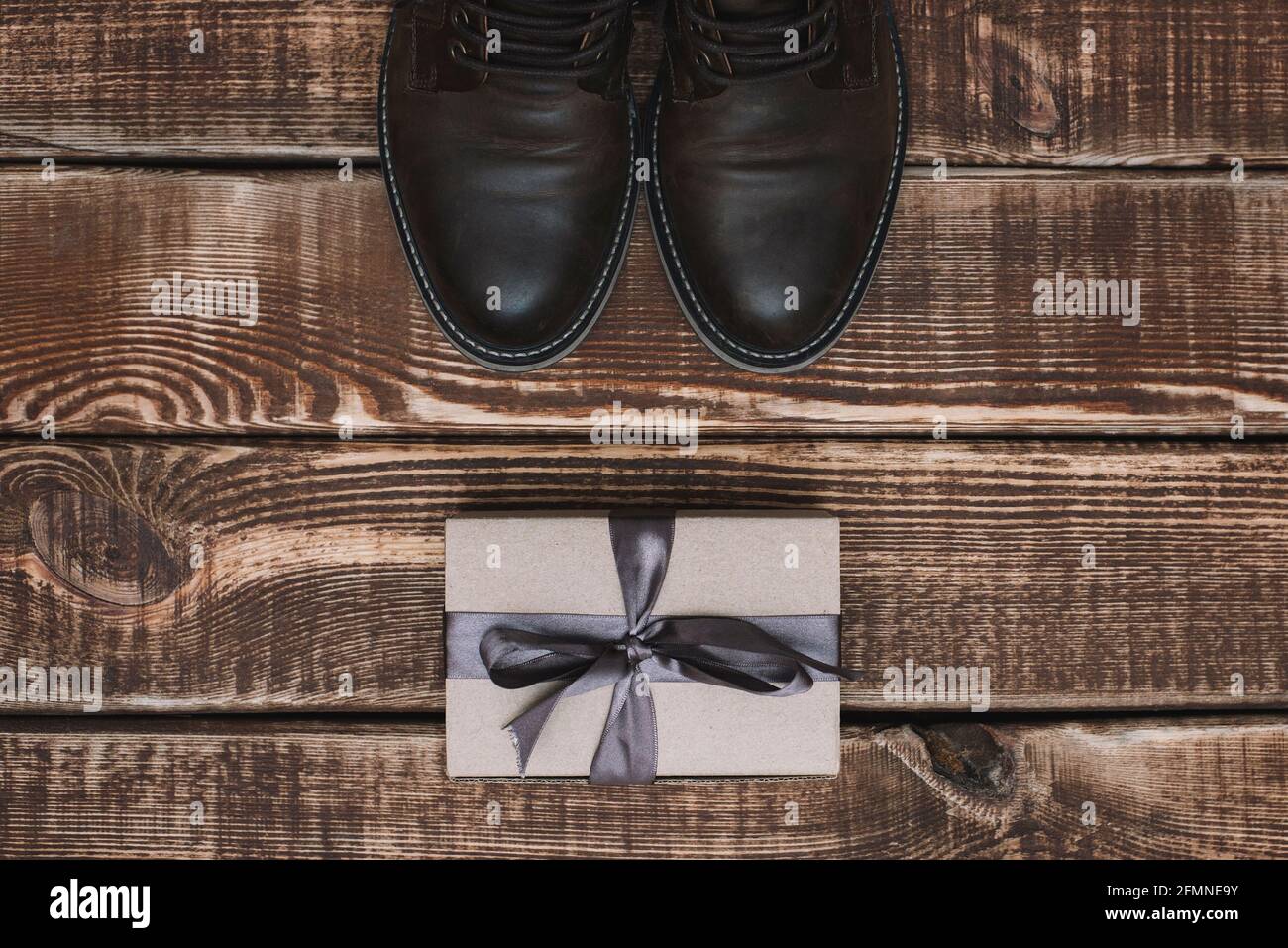 Caja de regalo con cinta y zapatos de cuero para hombre sobre fondo de  madera. Día del padre. Regalo para un hombre. Capa plana Fotografía de  stock - Alamy