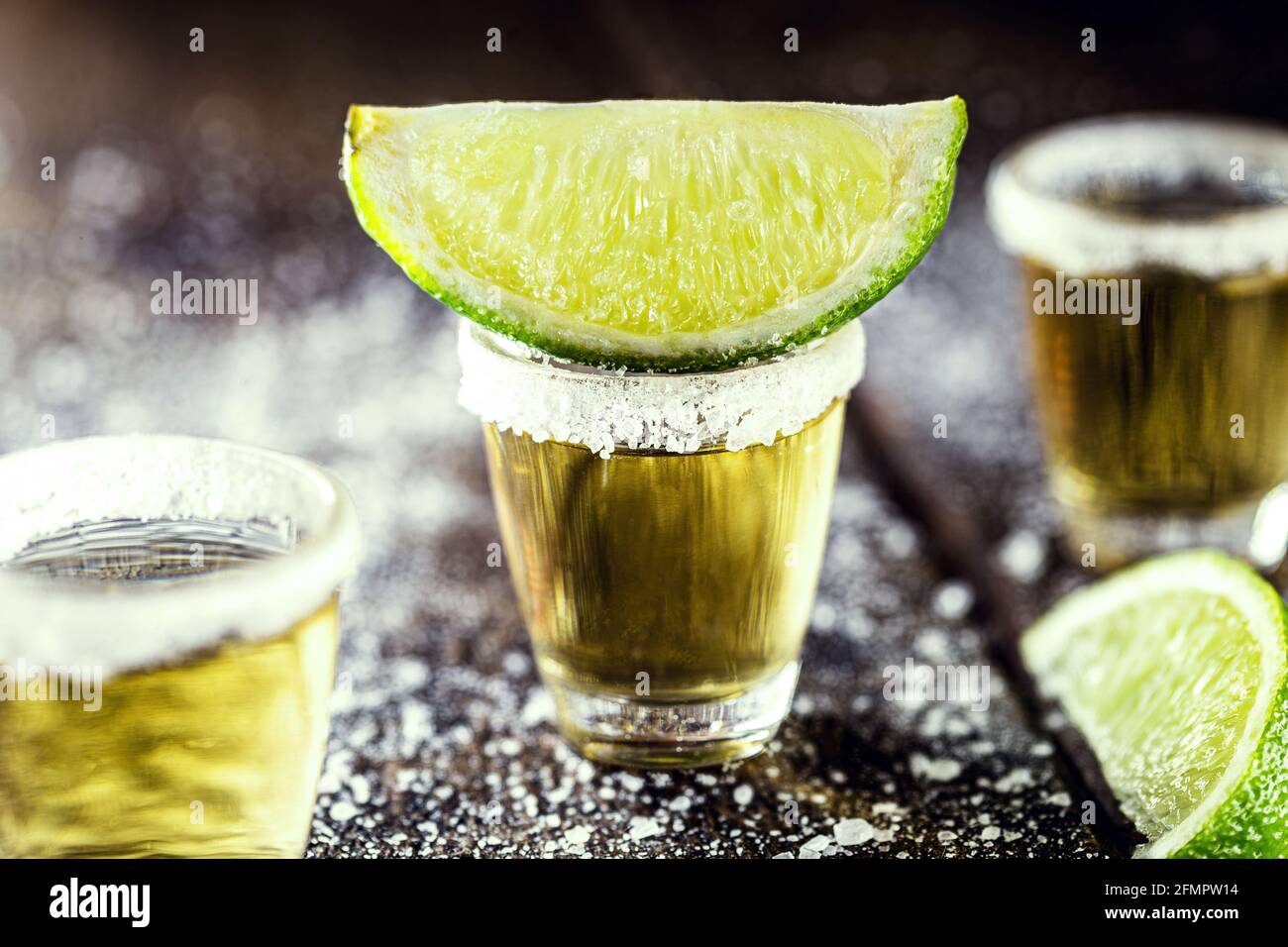 prestar talento Kakadu vaso de tequila, sobre mesa de madera, con limones y sal en el fondo.  bebida ardiente con vodka Fotografía de stock - Alamy
